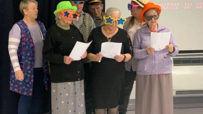 Grupa seniorów w śmiesznych przebraniach śpiewająca piosenki