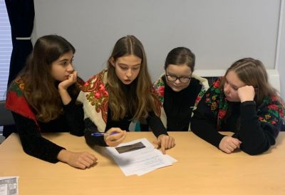 4 osobowa drużyna dziewczyn główkująca nad rozwiązaniem jednego z konkursowych zadań